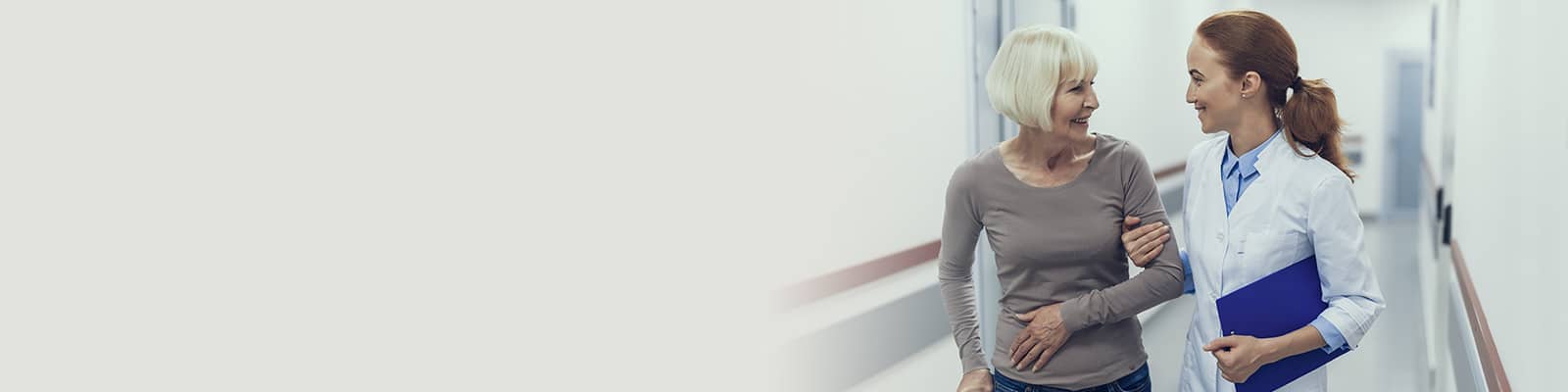 A nurse walking with an elderly woman