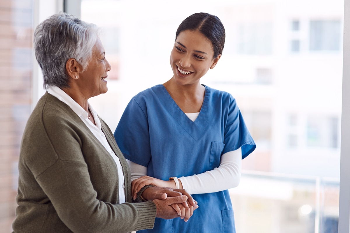 caregiver with senior woman and holding hands for care